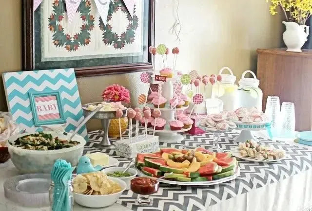 Chevron baby shower table with snacks, cake pops, fruit tray, and chevron decor