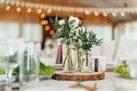 Rustic wedding table decor with glass jars, white flowers, and greenery centerpiece