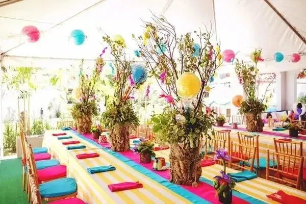 Colorful Hansel and Gretel birthday party table with striped tablecloths, lanterns, and floral centerpieces