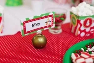 Holiday gift label reading Riley on a festive table with candies and red tablecloth