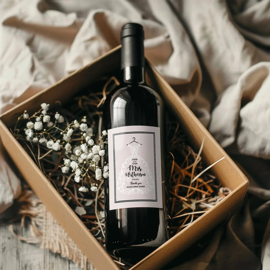 Elegant bridal shower wine bottle with personalized label in rustic gift box with flowers