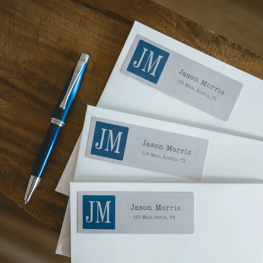 Personalized custom address labels on white envelopes with blue pen on wooden table