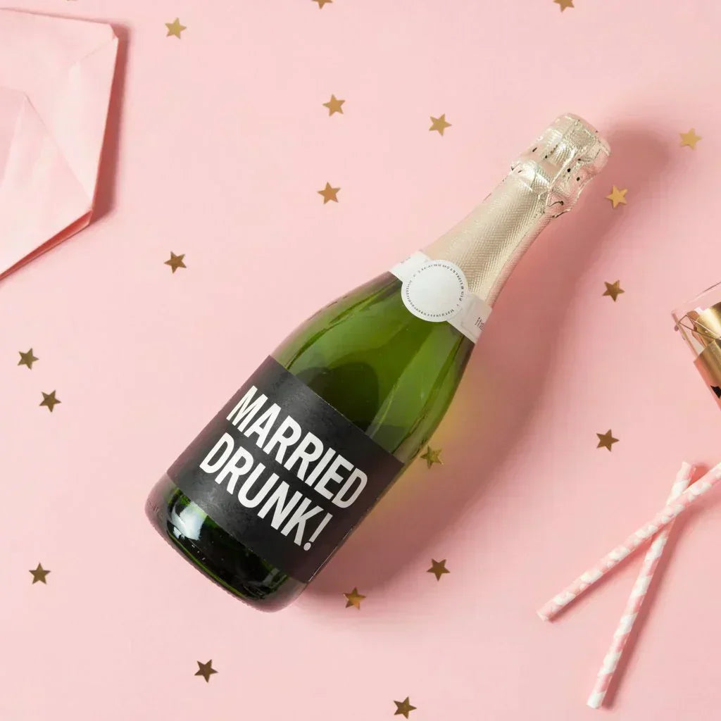 Custom mini champagne bottle with 'Married Drunk!' label on pink background with gold stars