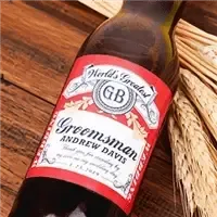 Custom groomsmen beer label on brown bottle, personalized gift on wooden surface with wheat