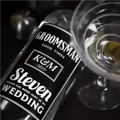 Custom groomsmen liquor label on a bottle beside a martini glass, personalized wedding gift