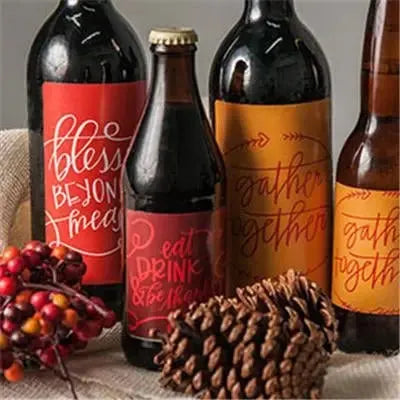 Thanksgiving decorations with personalized holiday beer bottle labels, pine cone, and berries