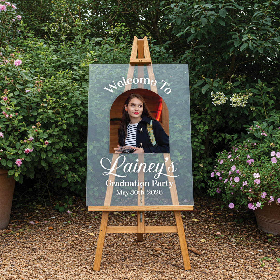 Graduation party photo frame with a person's photo on an easel outdoors.