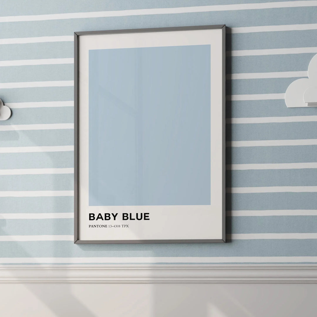 Framed baby blue Pantone nursery poster on striped pastel wall with white cloud decor