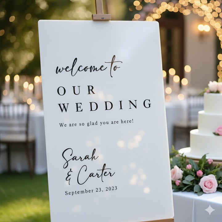 Wedding welcome sign with cake and floral decorations in the background
