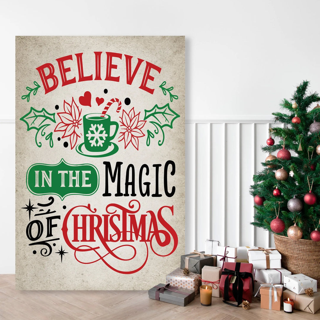 Christmas metal sign with Believe in the Magic of Christmas text and holiday mug illustration near decorated Christmas tree and gifts
