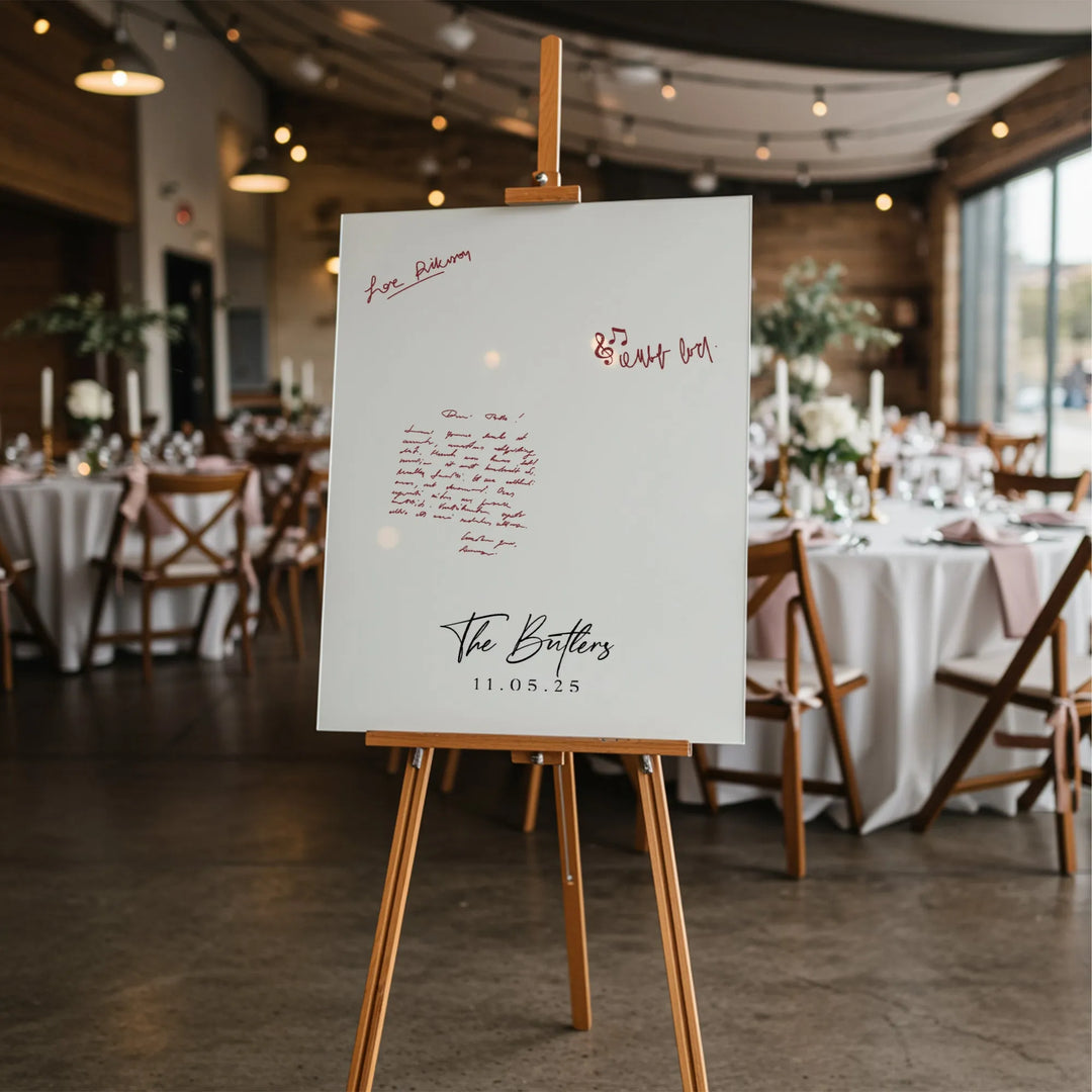 Wedding guest book sign on wooden easel with handwritten notes, The Butlers 11.05.25, reception tables