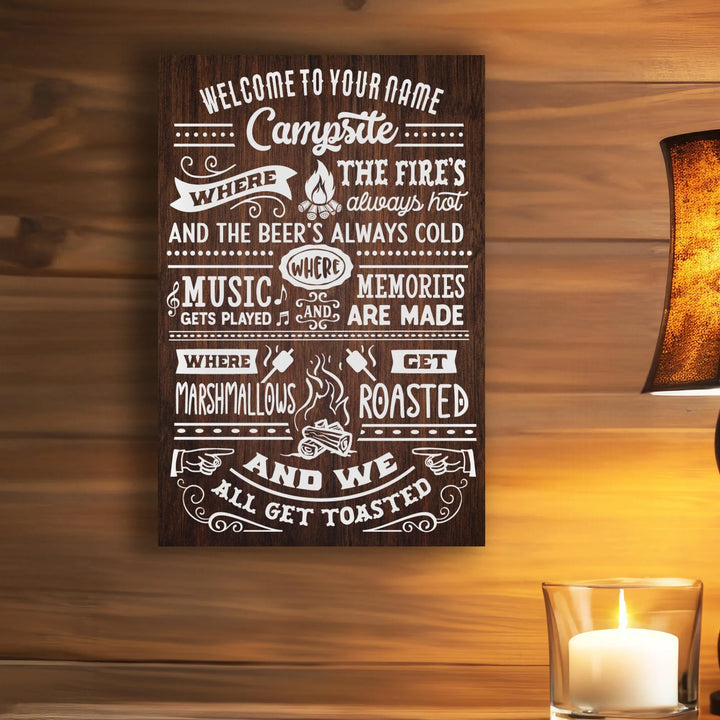 Rustic wooden campsite sign with white text about fires, cold beer, music, roasting marshmallows, and making memories