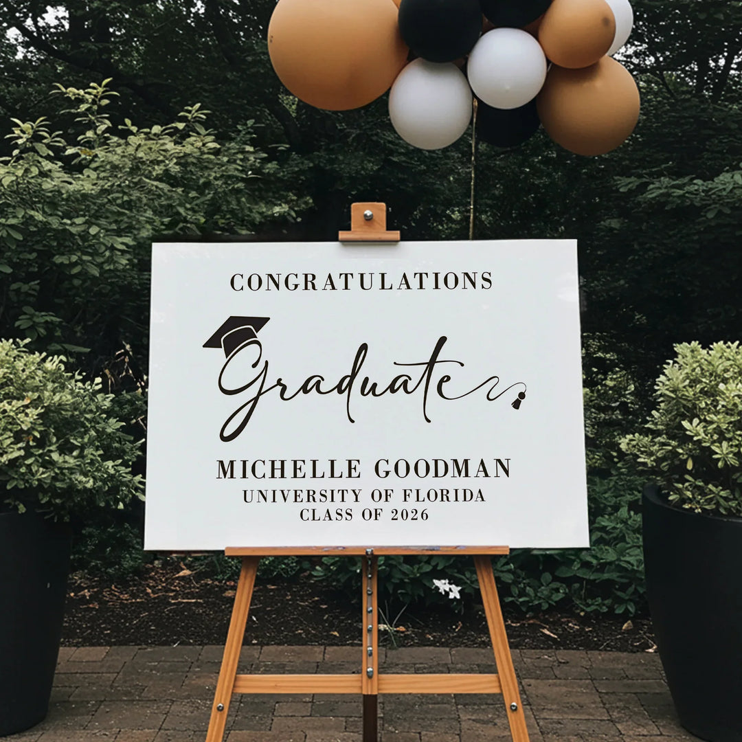 Graduation sign on an easel with balloons in the background