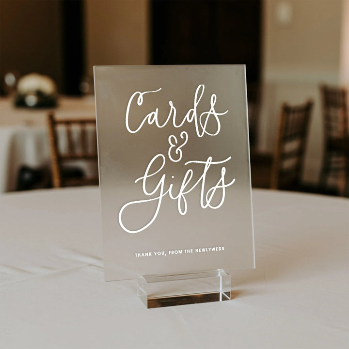 Elegant acrylic wedding table sign reading 'Cards & Gifts' in white script on a banquet table
