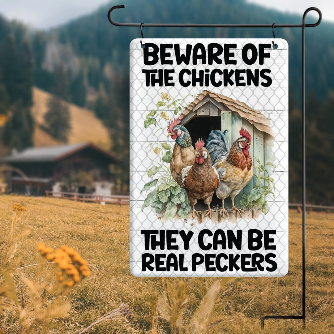 Metal garden flag with three chickens in front of a coop and text warning they can be real peckers