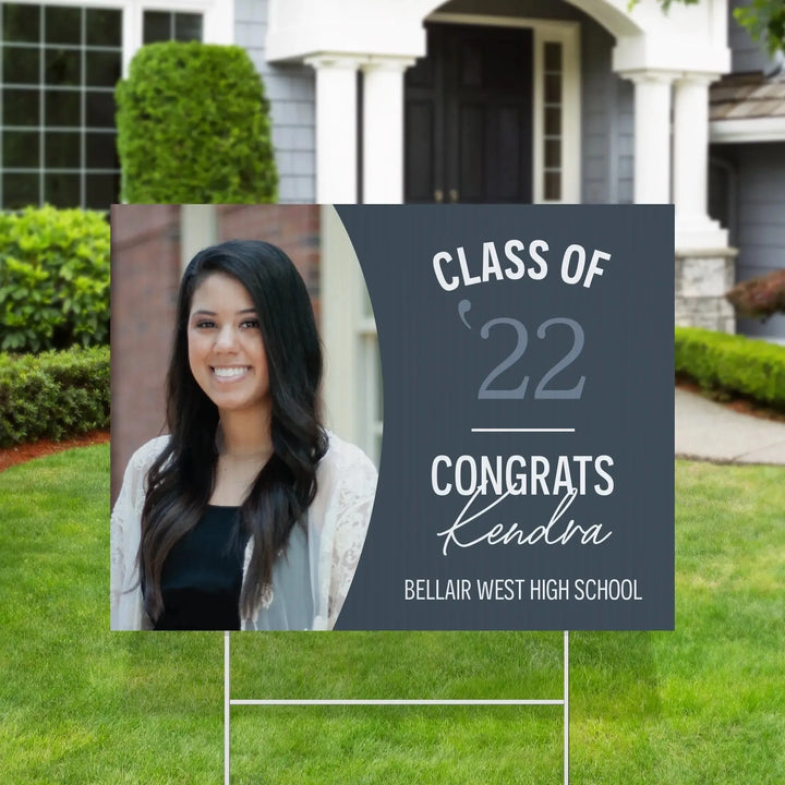 Graduation yard sign with Kendra's photo, text 'Class of 22 Congrats Kendra Bellair West High School' on lawn