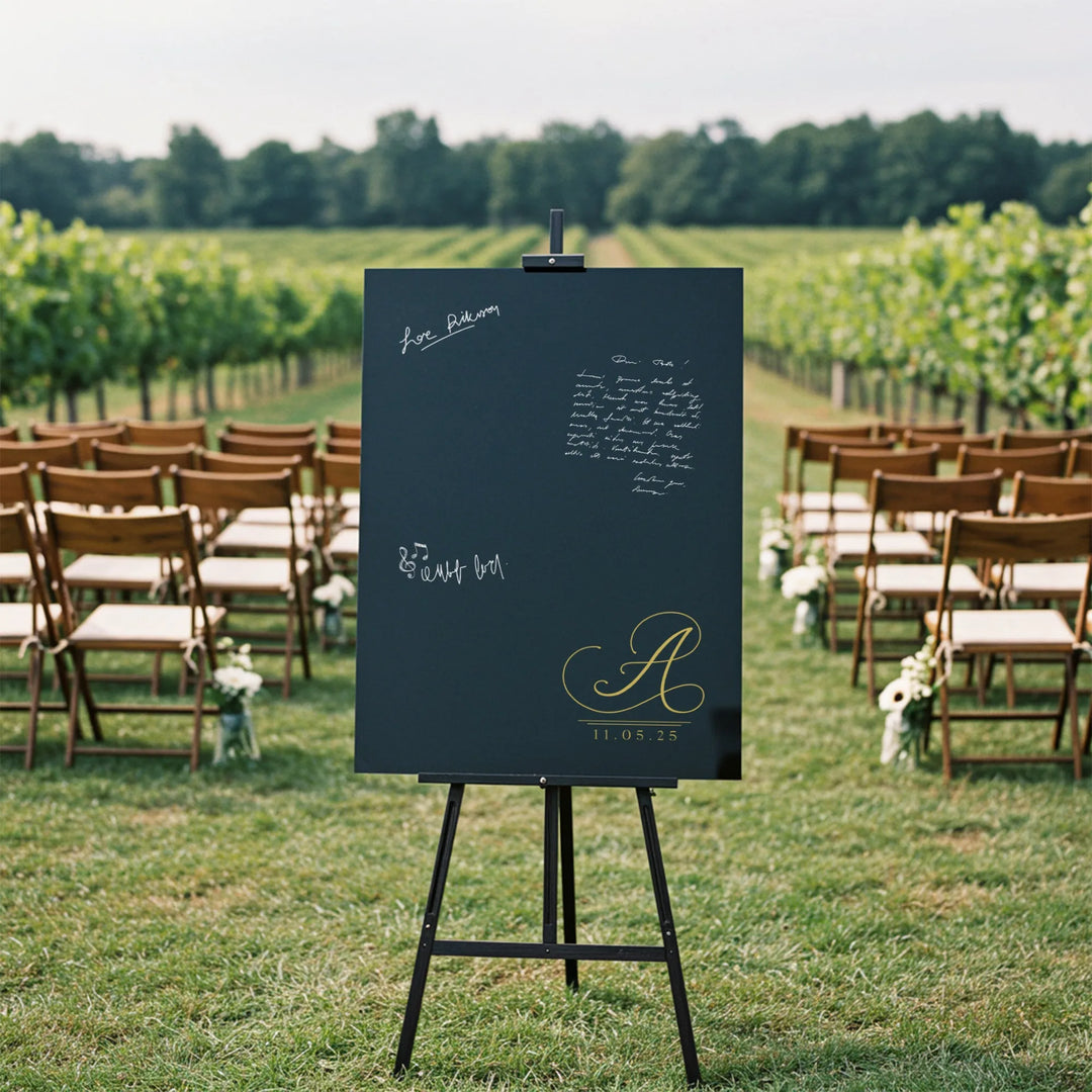 Black monogram guest book sign with gold letter A and date on easel at outdoor wedding vineyard