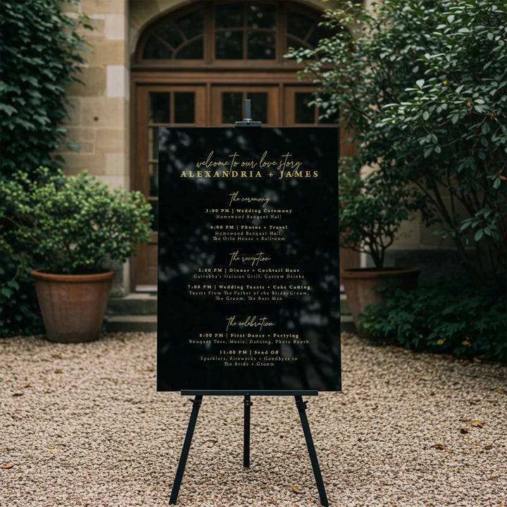 Elegant black wedding timeline sign with gold text for Alexandria and James at outdoor venue