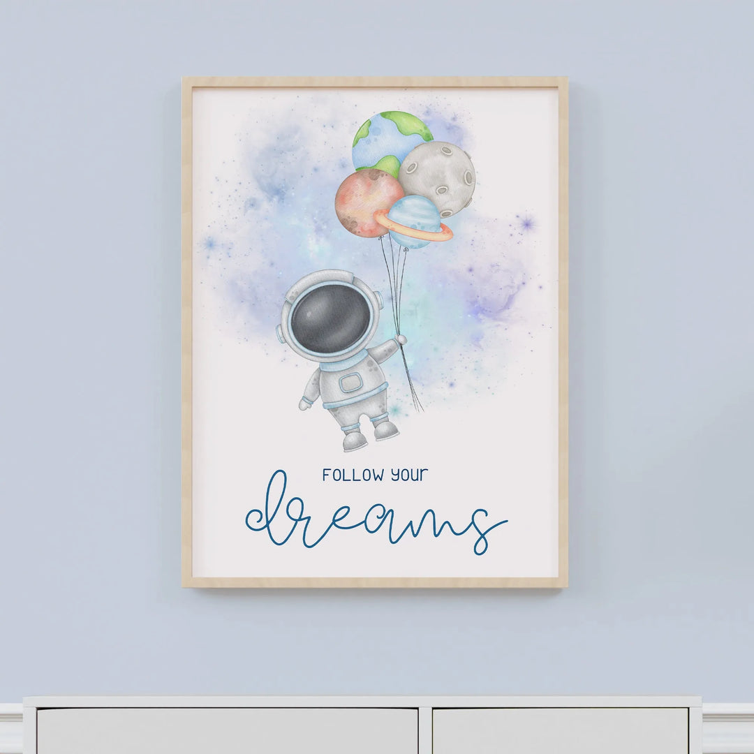 Nursery wall art of astronaut holding planet-shaped balloons with 'Follow your dreams' text