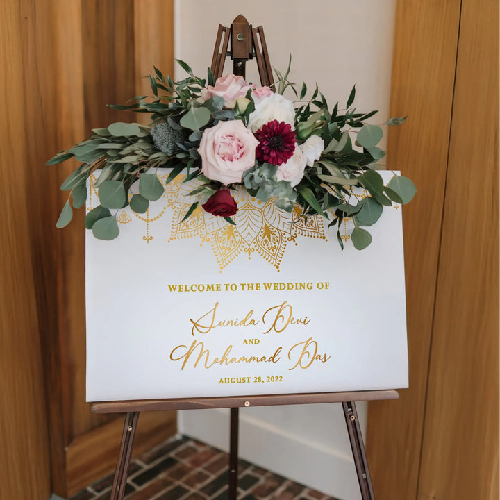 Elegant Indian wedding welcome sign with floral garland on wooden easel, August 28, 2022