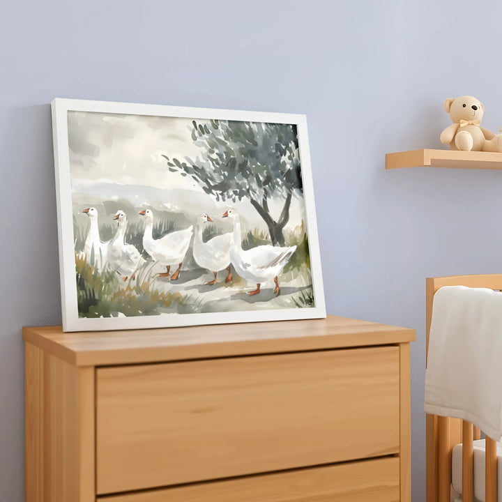 Watercolor nursery wall art of white geese walking near a tree, framed on wooden dresser