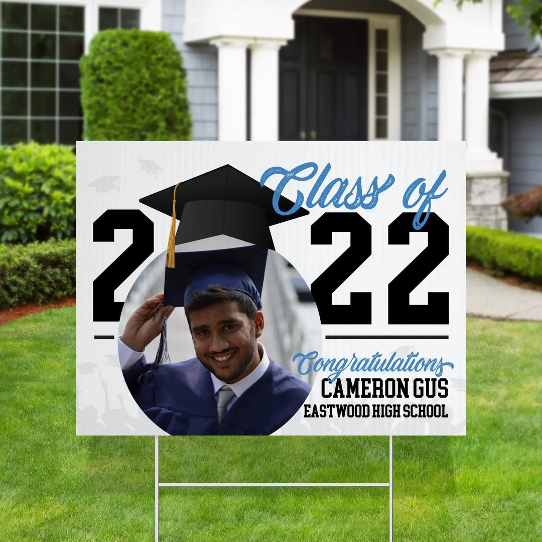 Yard sign on lawn with photo of male graduate, class of 2022, congratulating Cameron Gus from Eastwood High School