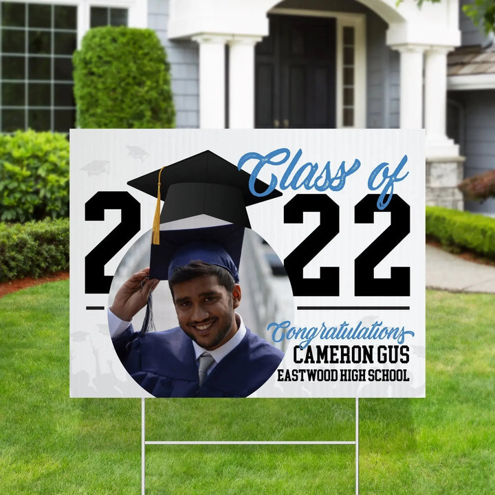 Yard sign on lawn with photo of male graduate, class of 2022, congratulating Cameron Gus from Eastwood High School