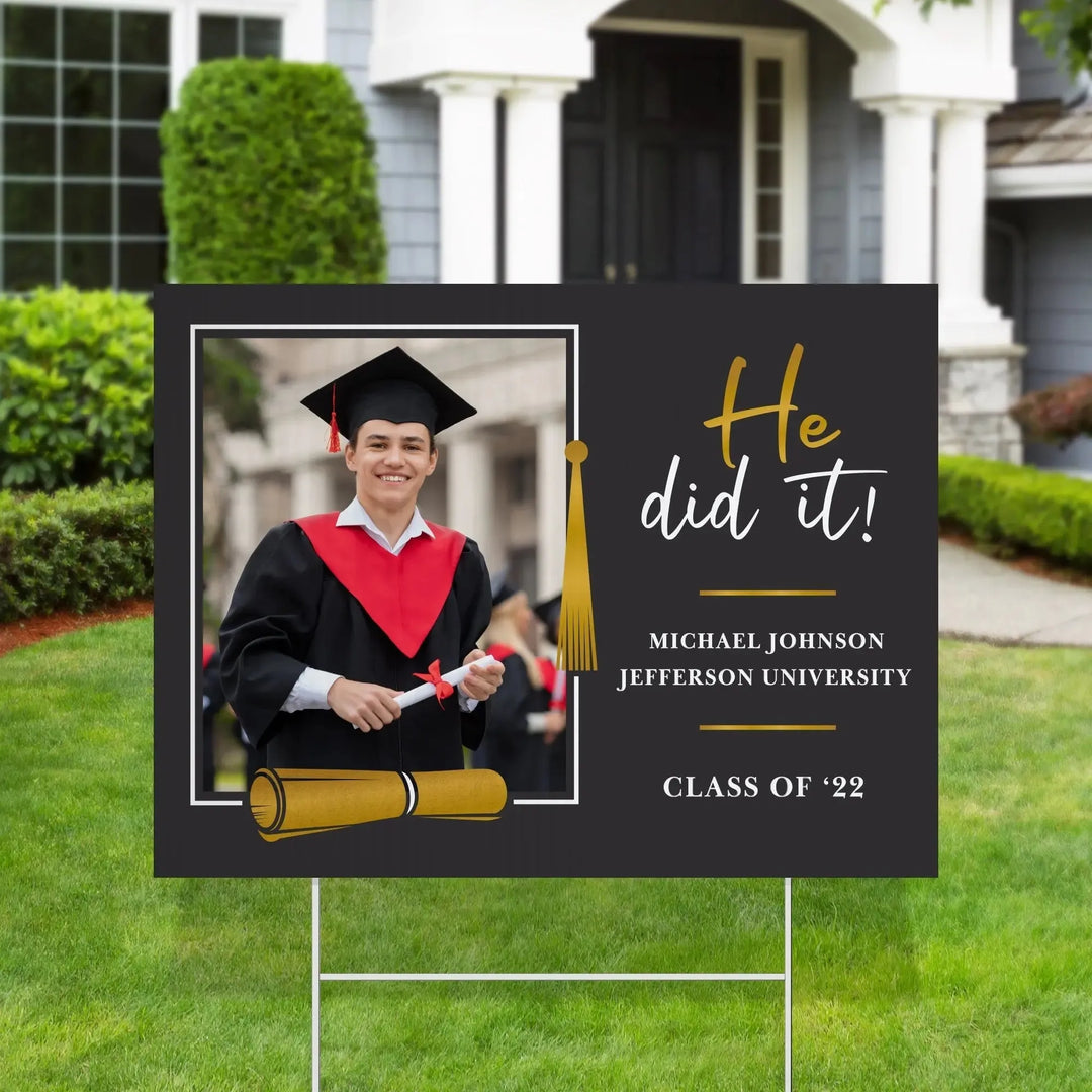 Graduation yard sign with smiling male graduate in cap and gown, text He did it, Michael Johnson, Jefferson University, Class of '22