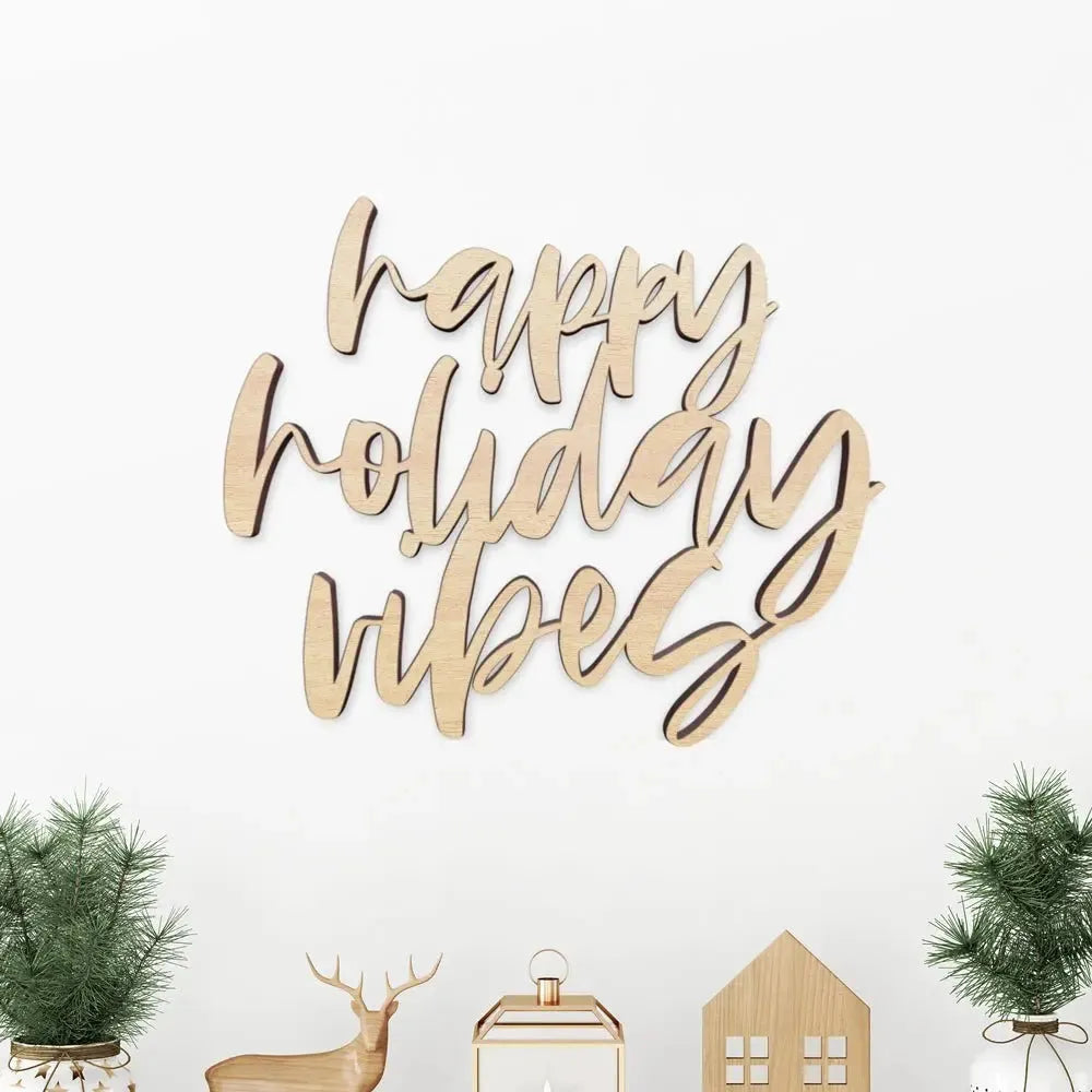 Wooden happy holiday vibes sign with minimalist Christmas decor and small pine trees
