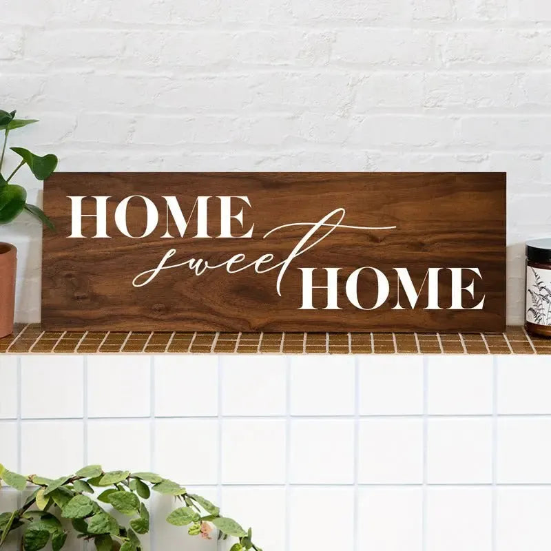Home Sweet Home wood sign on a tile shelf with houseplants and candle, rustic wall decor