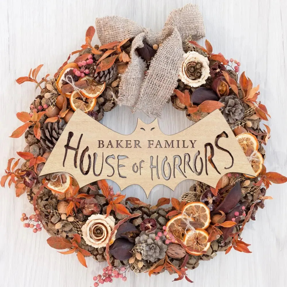 House of Horrors sign on autumn wreath with dried fruit, pinecones, and burlap bow