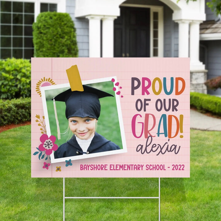 Colorful personalized yard sign with a young girl in graduation cap, proud of our grad Alexia, Bayshore Elementary 2022