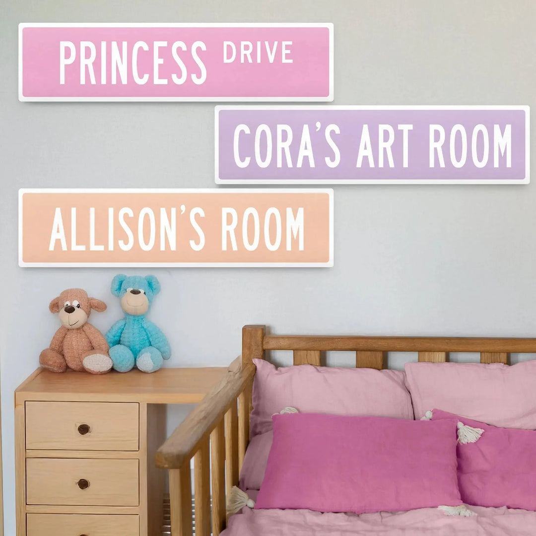 Kids room with personalized metal street signs reading Princess Drive, Cora's Art Room, and Allison's Room above a wooden bed and drawers