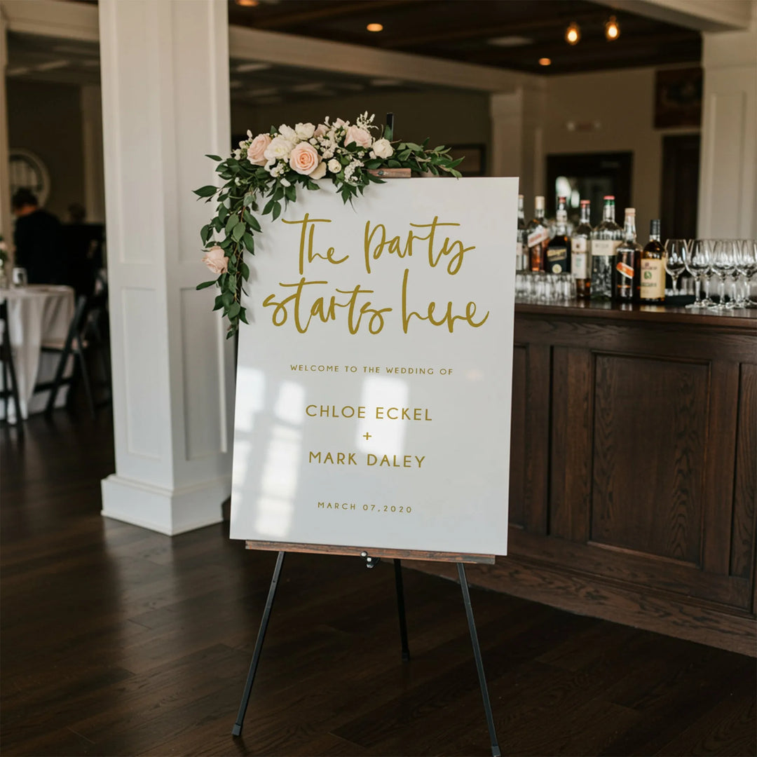 Wedding welcome sign with floral decoration reading The party starts here for Chloe Eckel and Mark Daley