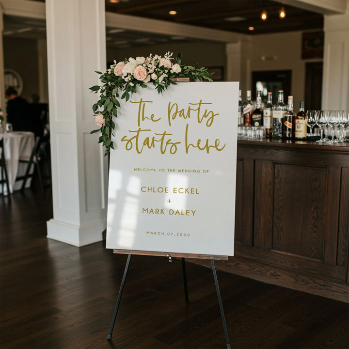 Wedding welcome sign with floral decoration reading The party starts here for Chloe Eckel and Mark Daley