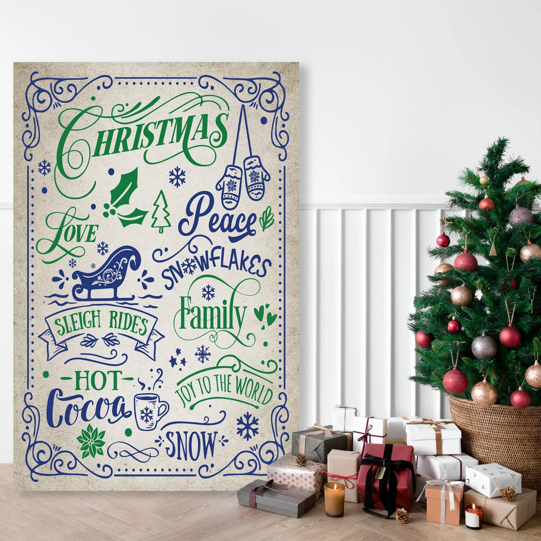 Christmas themed metal sign with words like Peace, Family, Hot Cocoa next to decorated Christmas tree and gifts