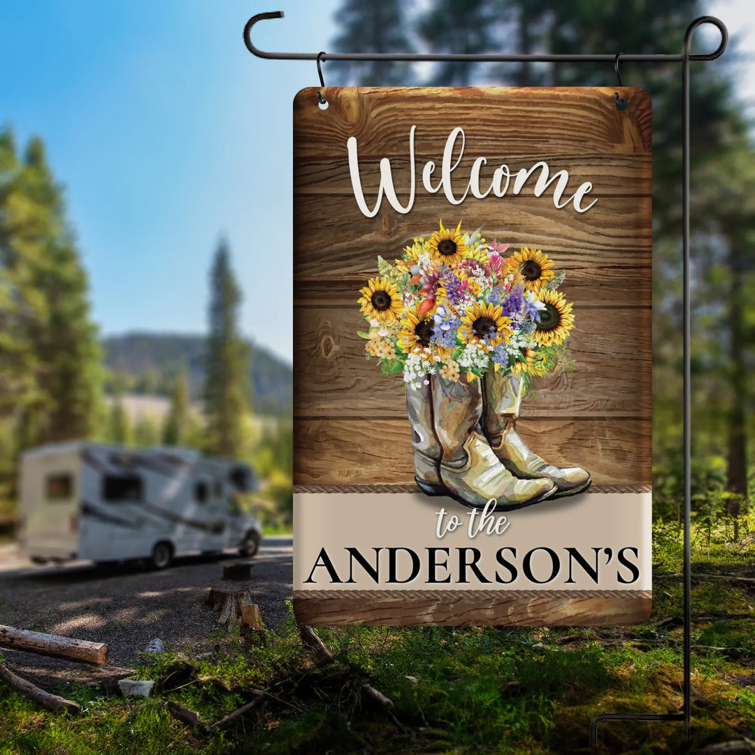 Personalized garden flag with cowboy boots filled with flowers and Welcome to the Anderson's text outdoors