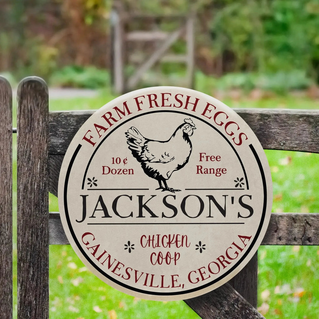 Round personalized metal sign on wooden fence reading Jackson's farm fresh eggs chicken coop Gainesville Georgia