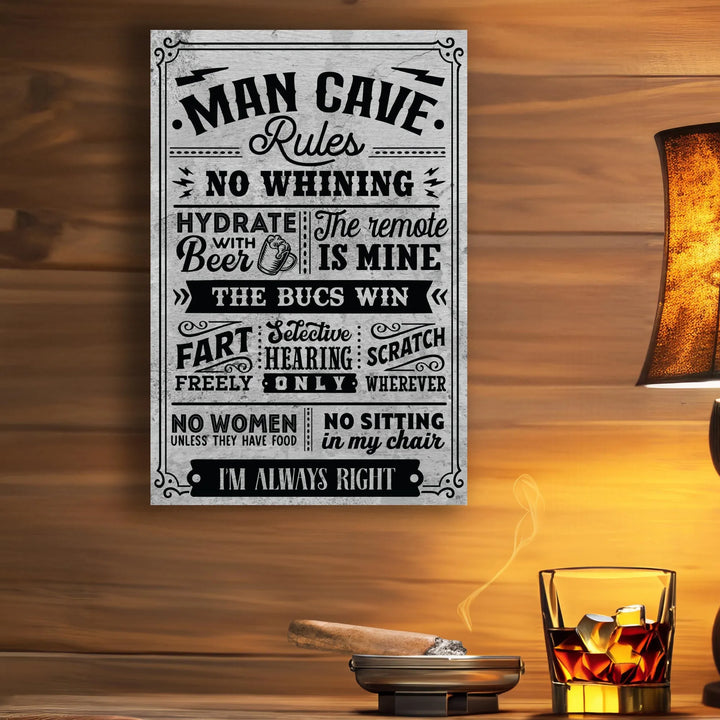 Metal man cave rules sign on wooden wall with lit cigar in ashtray and glass of whiskey with ice