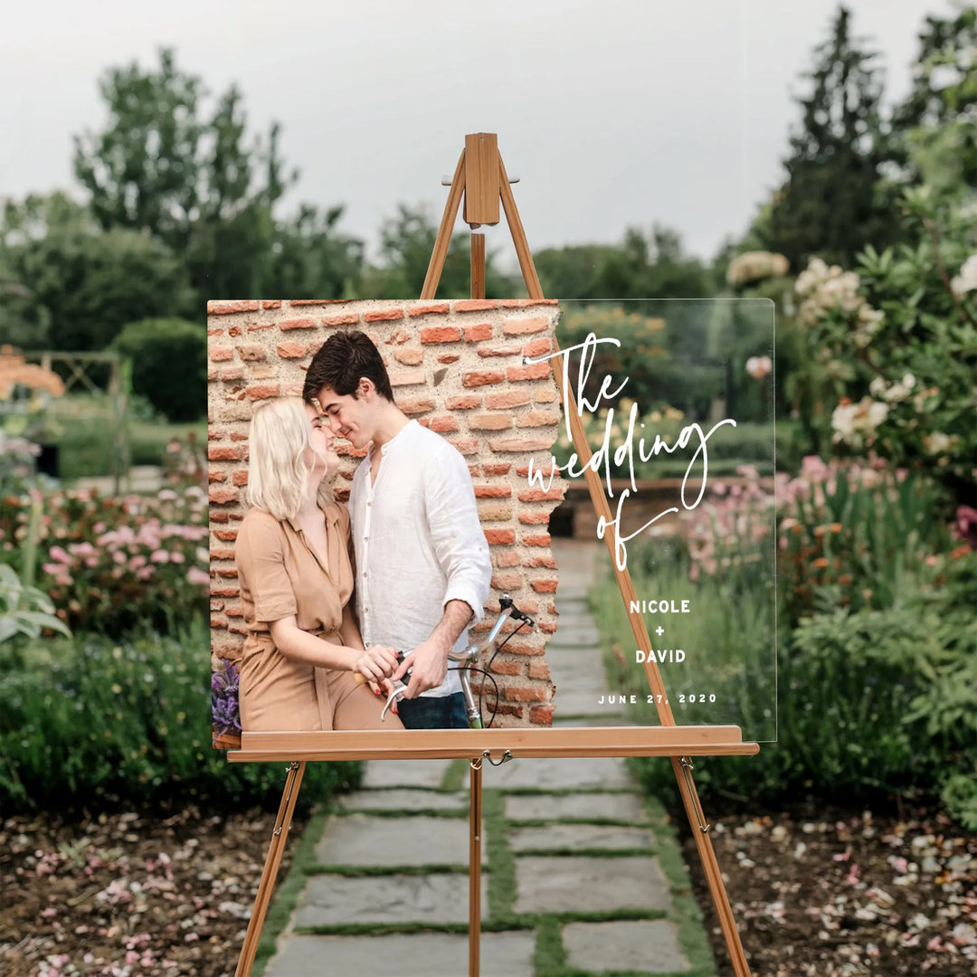 Wedding welcome sign on easel with couple photo and text Nicole + David June 27, 2020 in garden