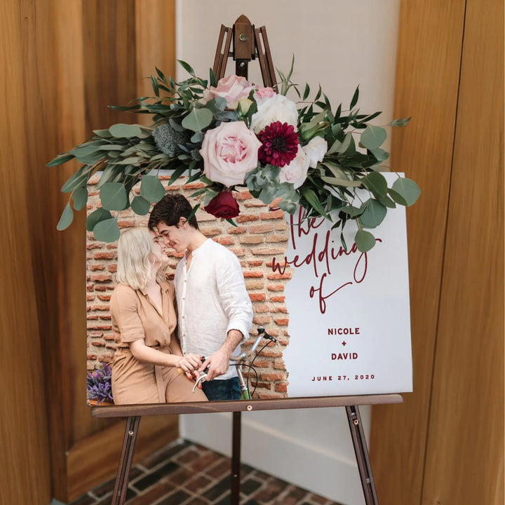 Wedding welcome sign with photo of couple Nicole and David, floral arrangement on easel
