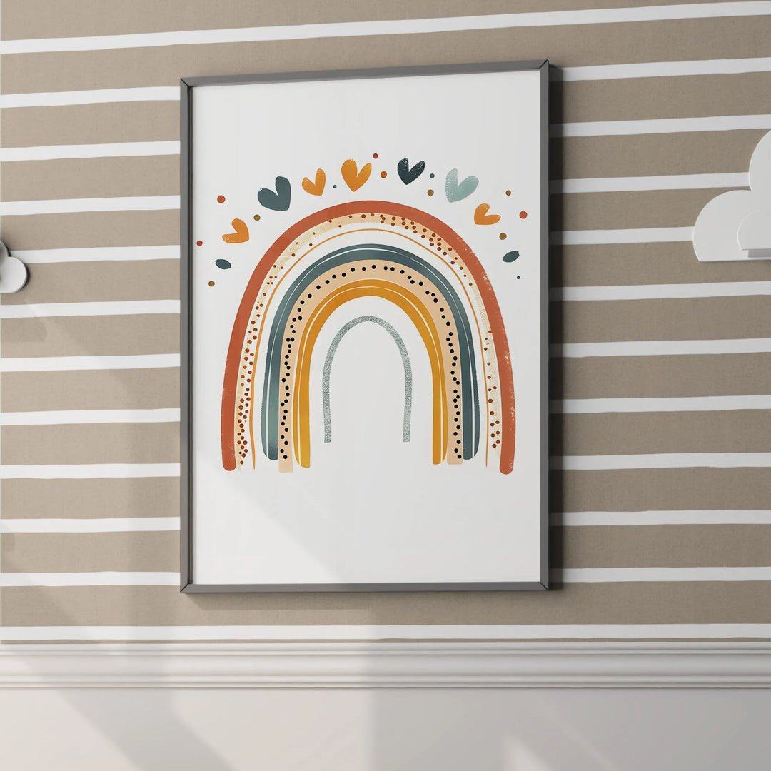 Framed colorful rainbow wall art with hearts above, hanging on beige and white striped nursery wall
