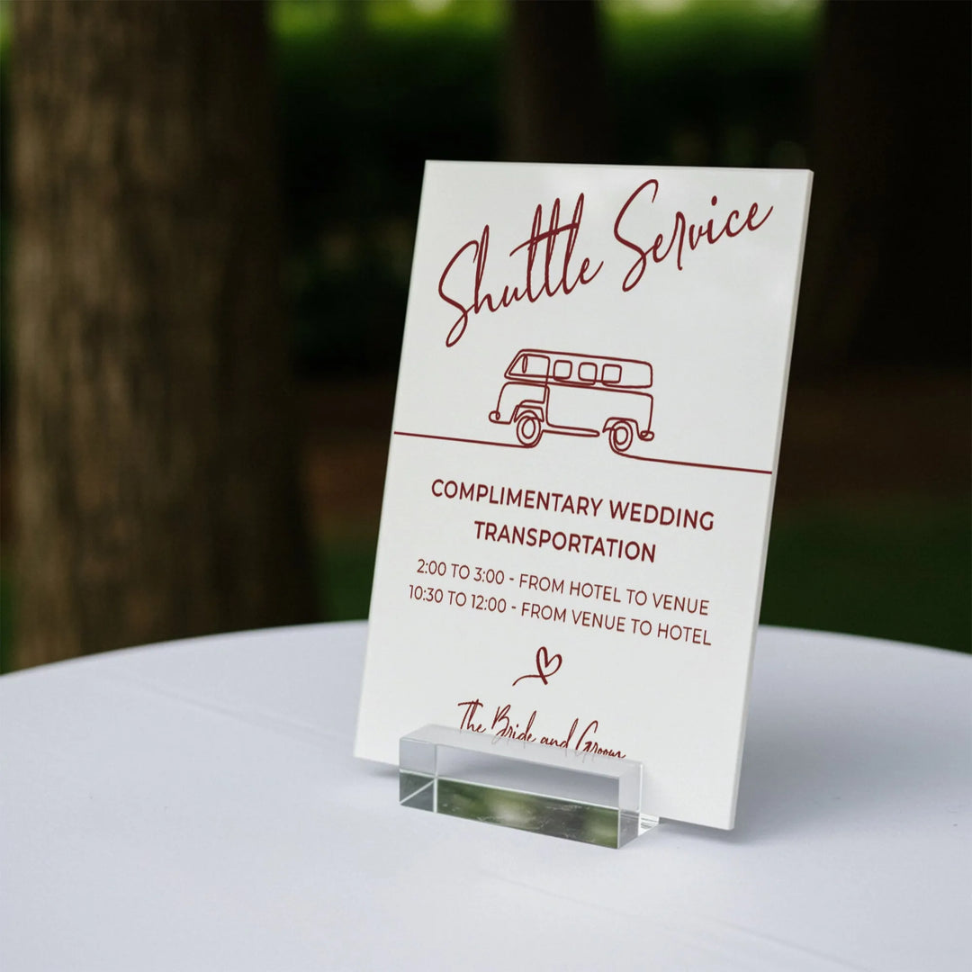 Wedding shuttle service sign on white table offering complimentary transportation between hotel and venue