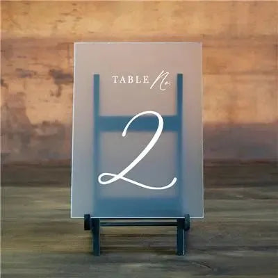 Simple acrylic table number sign with elegant white text 'Table No. 2' on wooden background