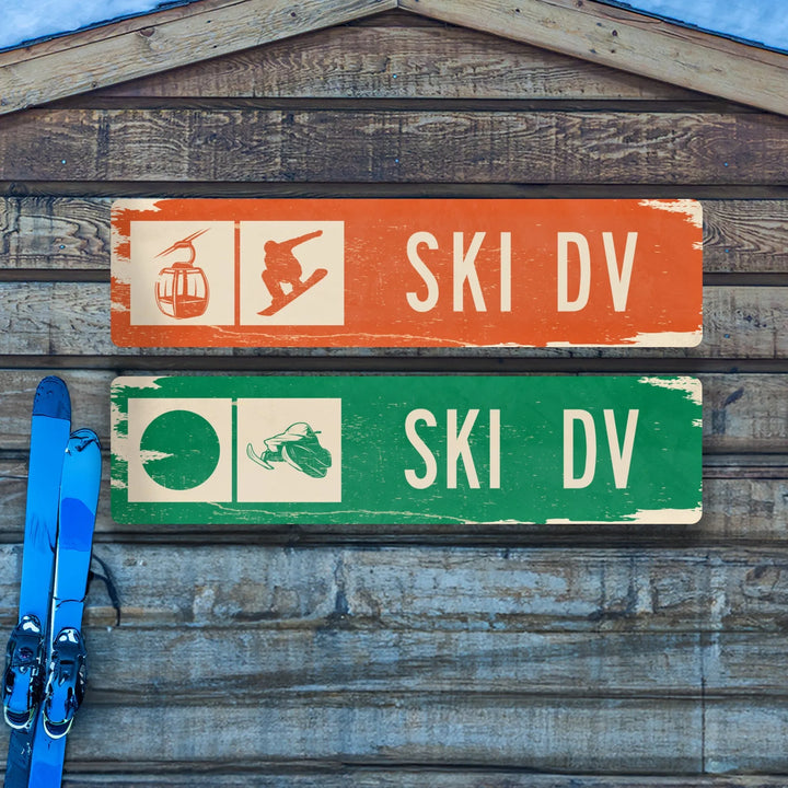 Rustic wooden wall with two distressed metal ski trail signs and blue skis leaning against it