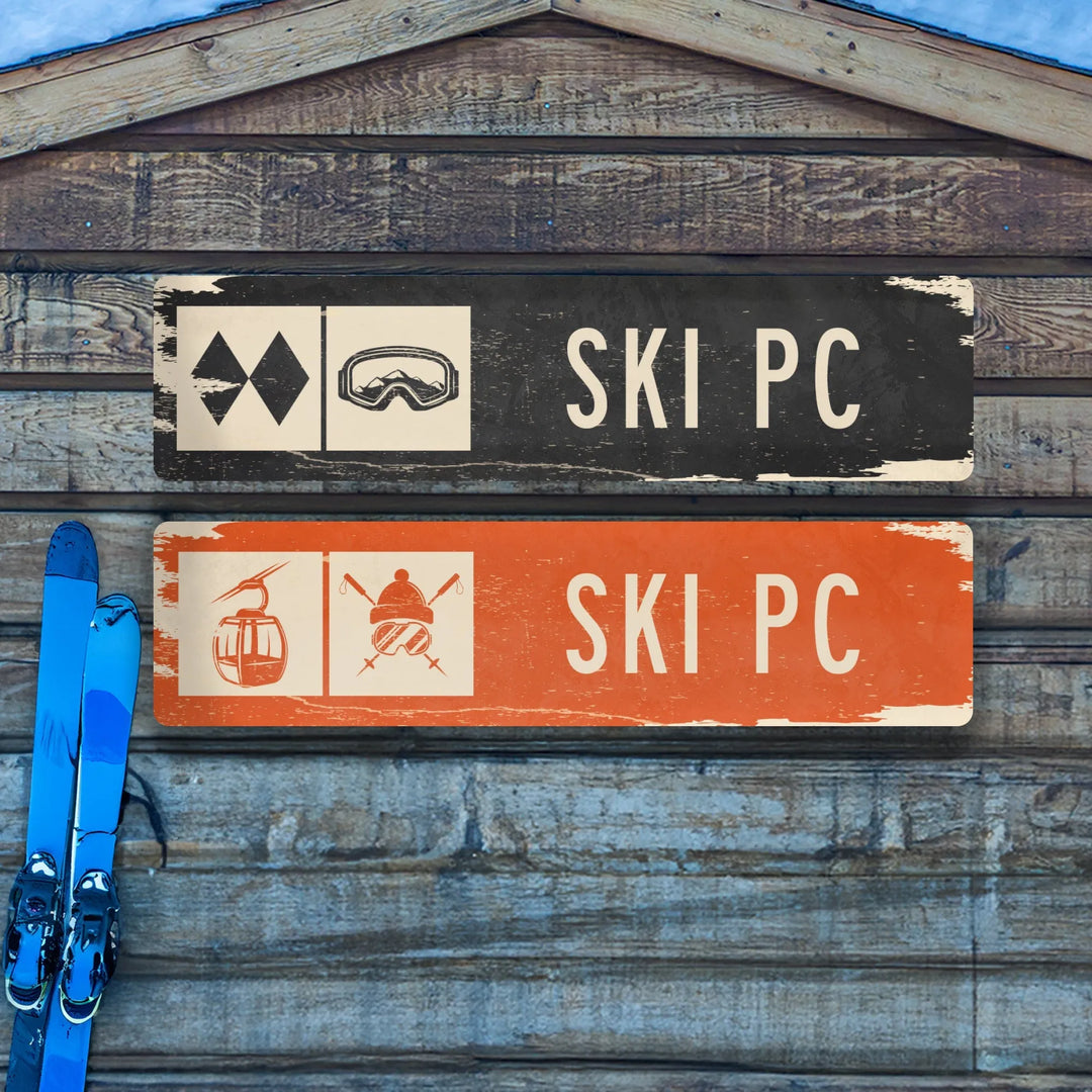 Rustic wooden wall with two distressed metal ski trail signs, blue skis leaning beside them