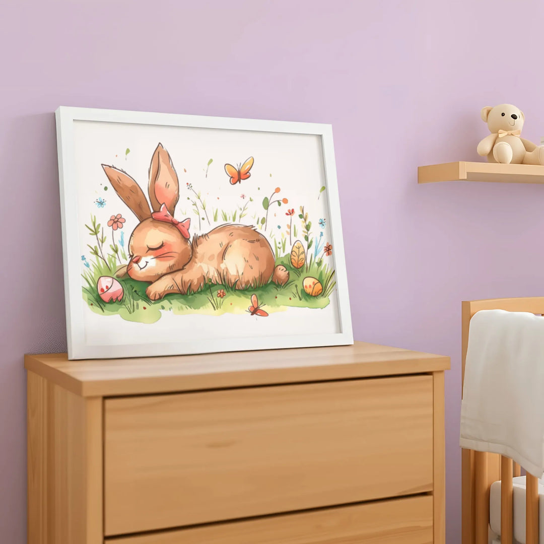 Framed nursery poster of a sleepy bunny with flowers, butterflies, and Easter eggs on wooden dresser