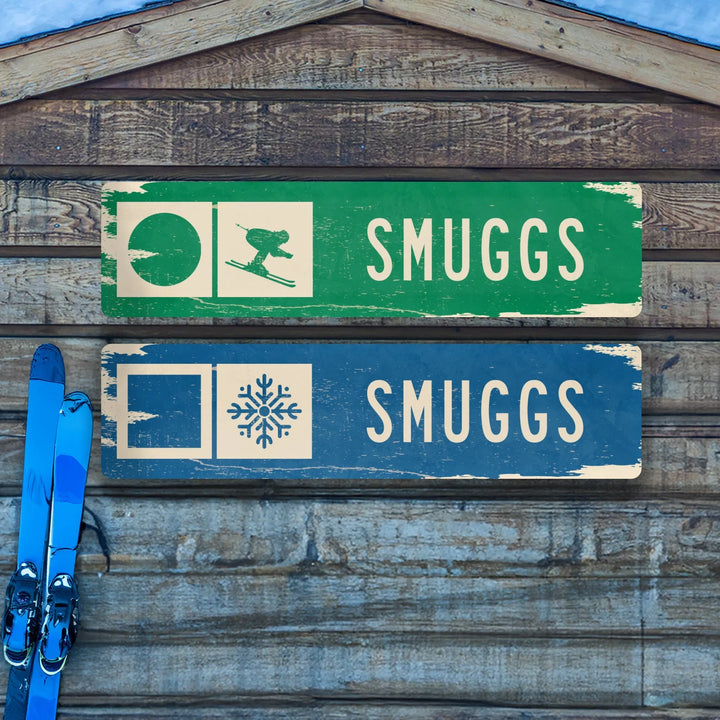 Rustic wooden wall with two distressed Smuggs ski trail signs and a pair of blue skis