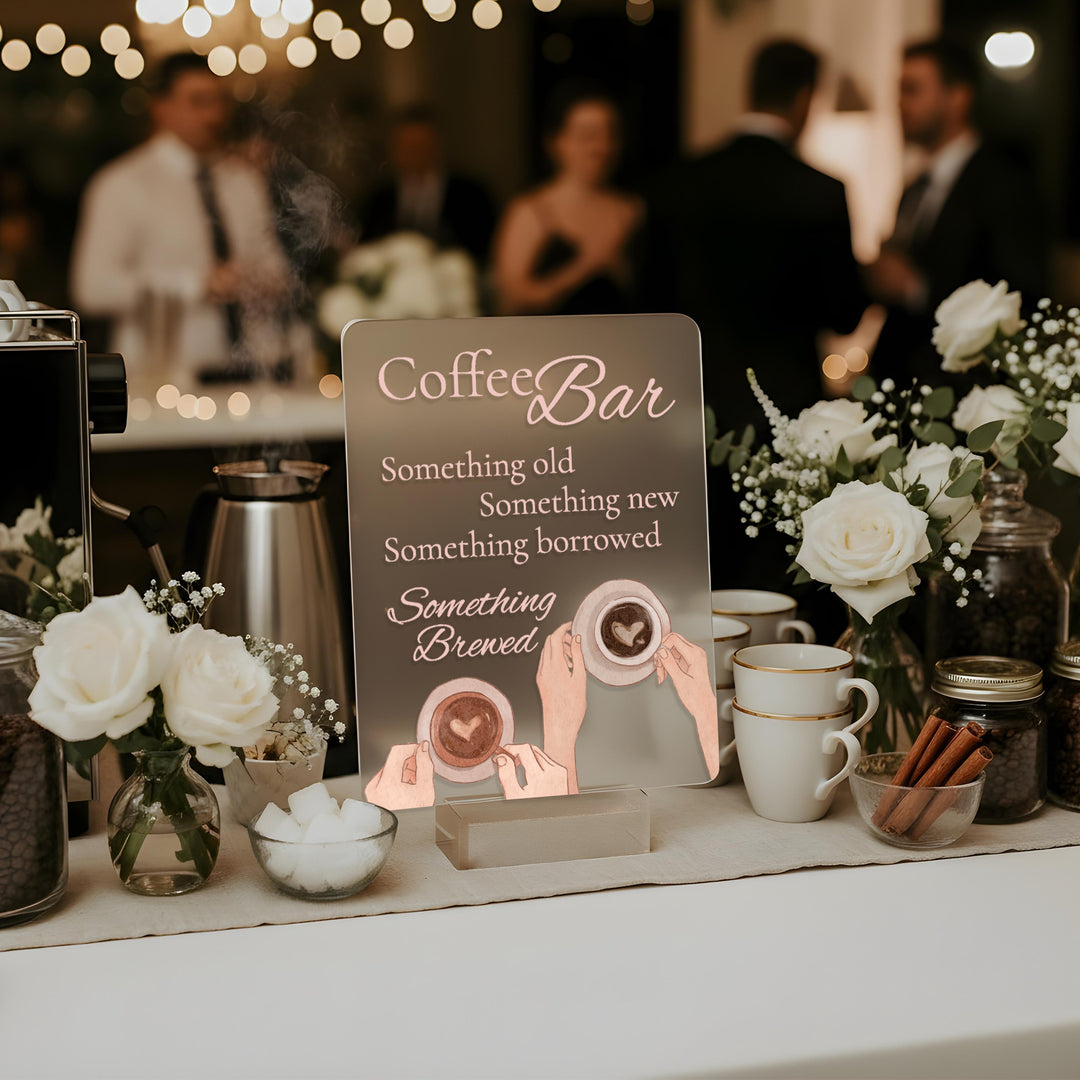 Coffee bar setup with decorative sign and flowers at a wedding reception.