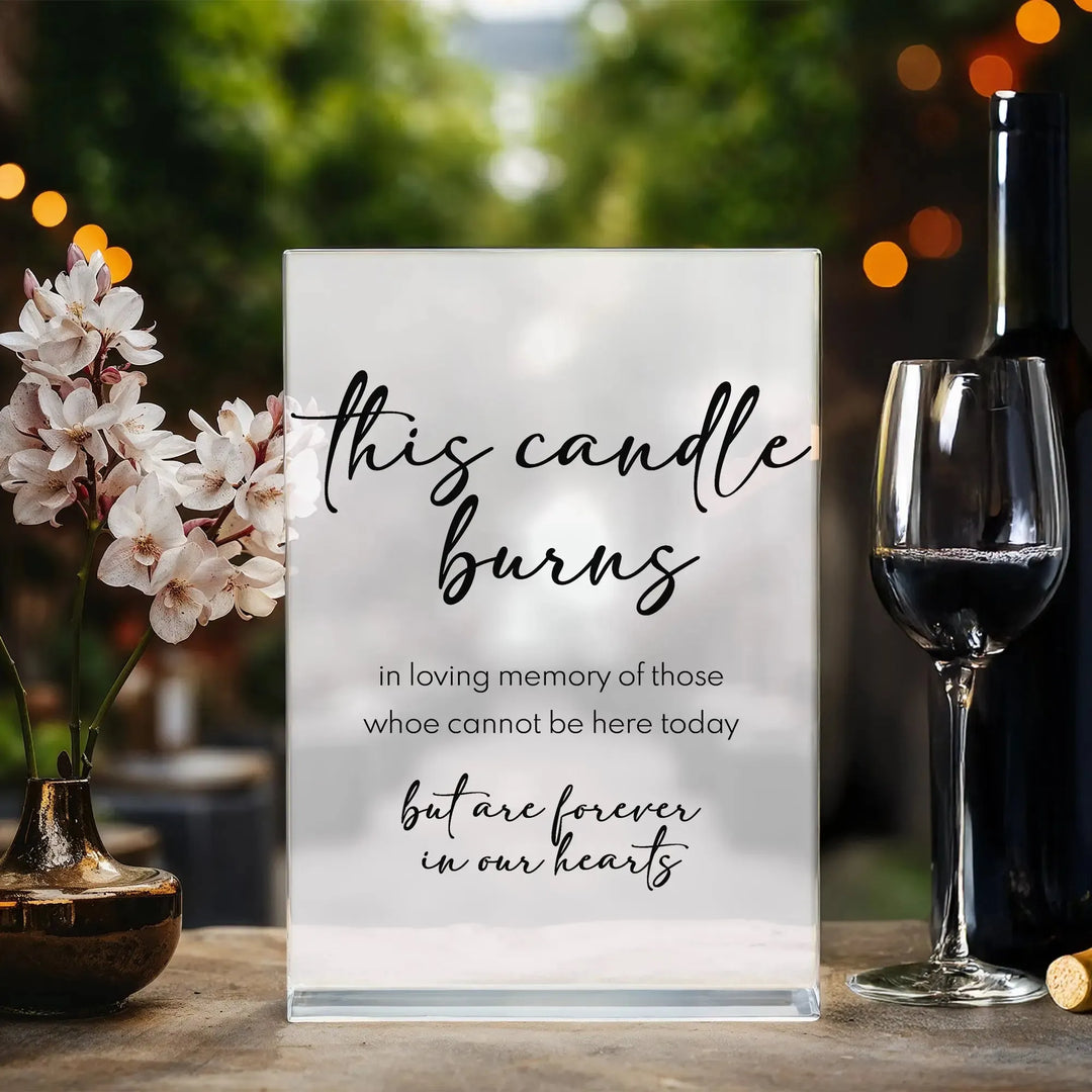 Memorial wedding table sign with floral vase and wine glass on wooden surface, outdoor setting